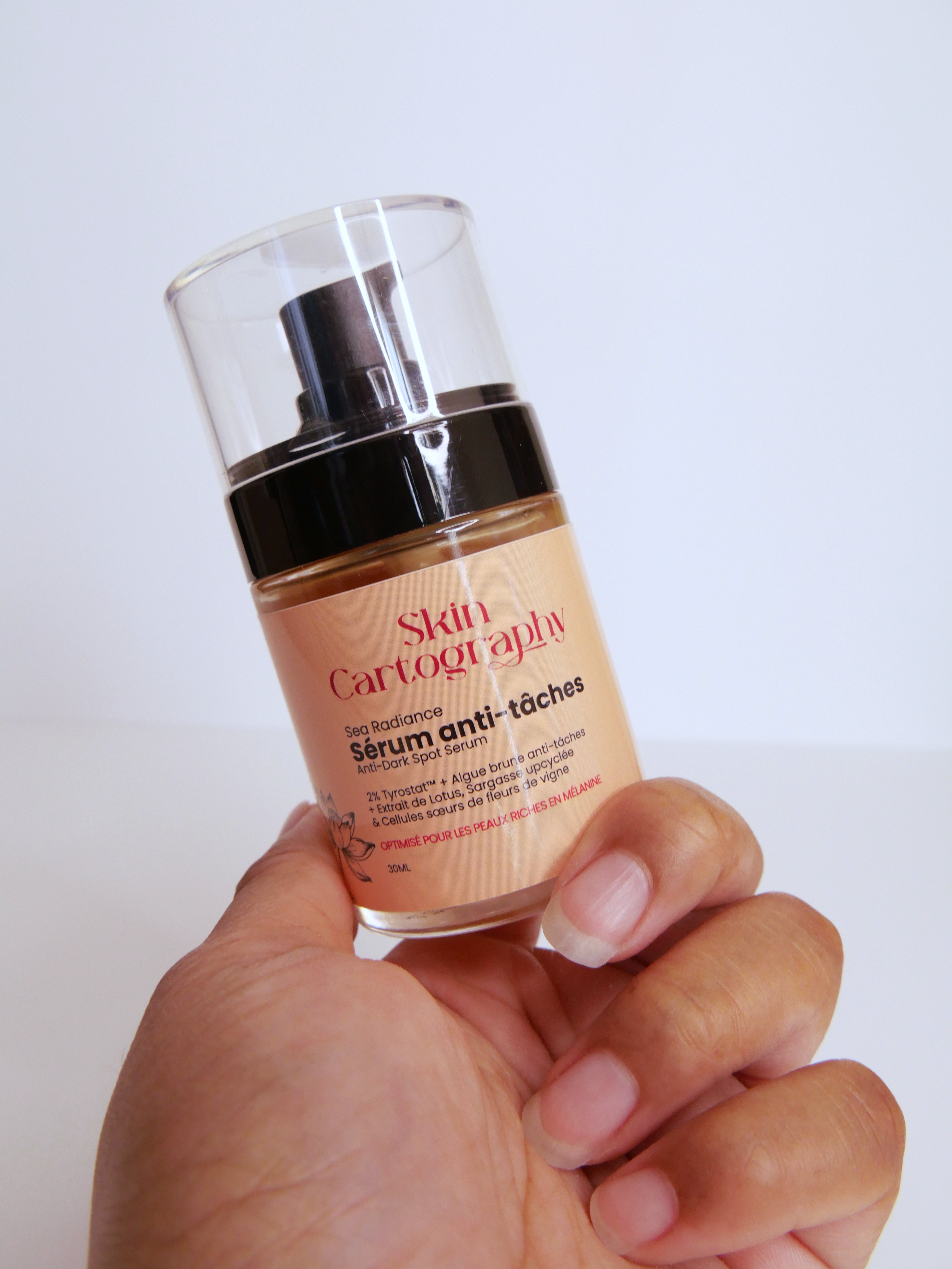 Main métisse tenant serum anti-tâche